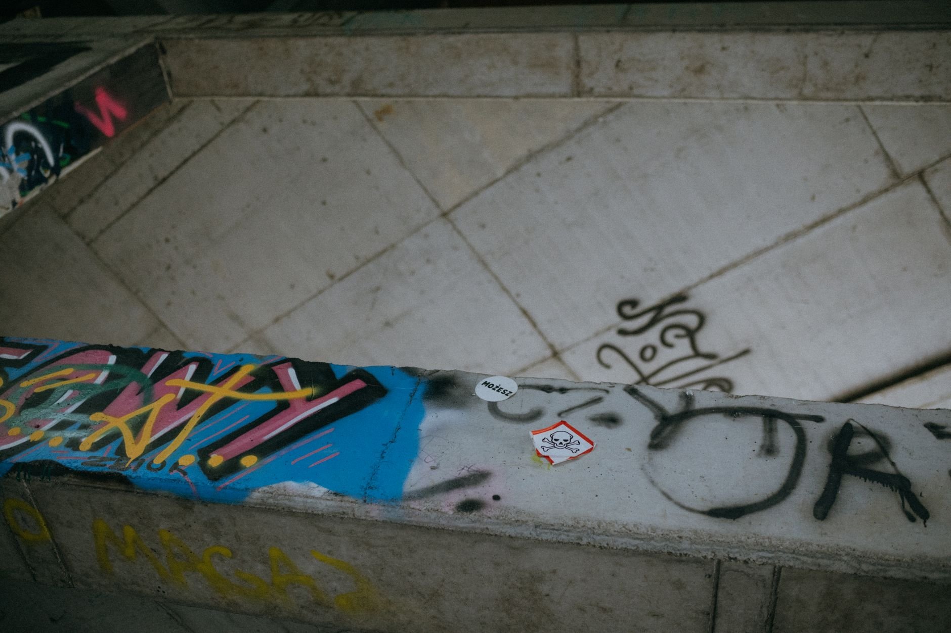 Colorful graffiti and stickers on a concrete wall, depicting urban art subculture.